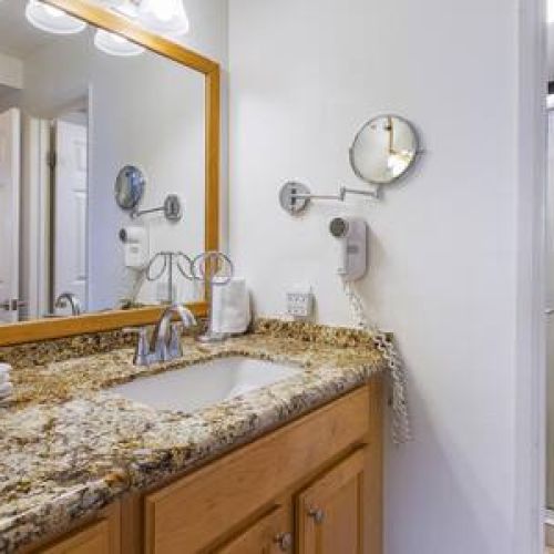 Bathroom features walk in shower, single sink vanity, and luxury organic bottles of bath essentials