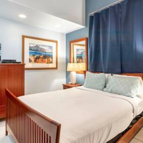 Downstairs bedroom features a queen size bed, Smart TV with cable and ceiling fan.