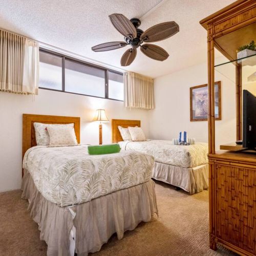 Two twin beds in second bedroom with TV, ceiling fan, and central air conditioning.