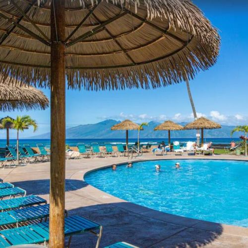 Oceanfront pool with palapa sun umbrellas and plenty of seating.
