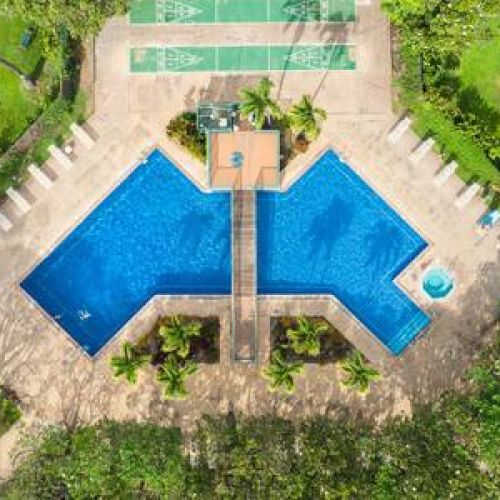 Large heated swimming pool with spa, shuffleboard, and plenty of seating