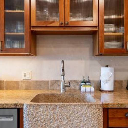 Custom kitchen sink and fully stocked cabinets