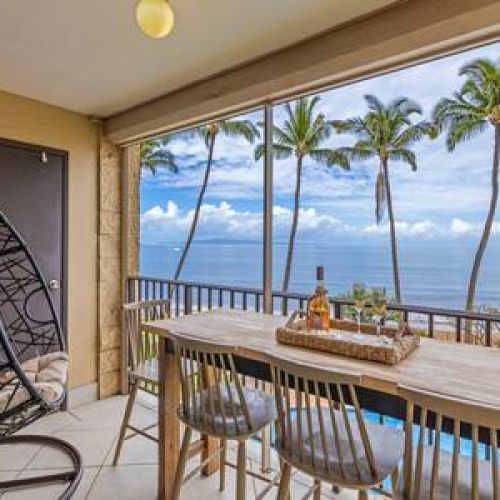 Private oceanfront lanai with bar top seating and an egg swing