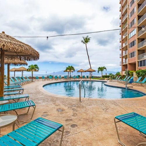 Resort pool with plenty of seating and palapas for shade.
