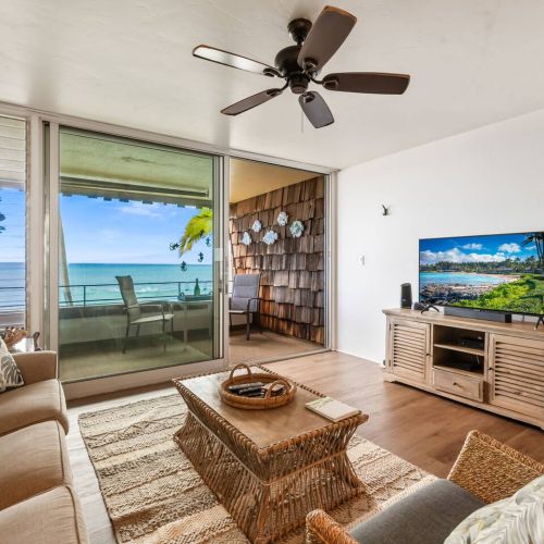 Living room features smart tv, ceiling fan, and a coastal aesthetic