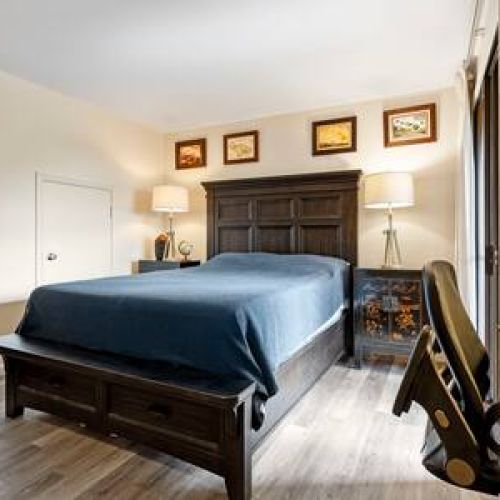 Downstairs bedroom with work area, private lanai, and queen bed