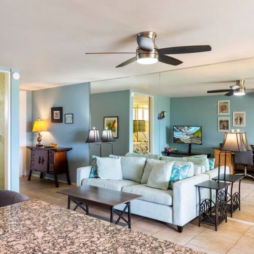 Living room features Smart TV with cable, ceiling fan, sofa sleeper, and designated work desk area.